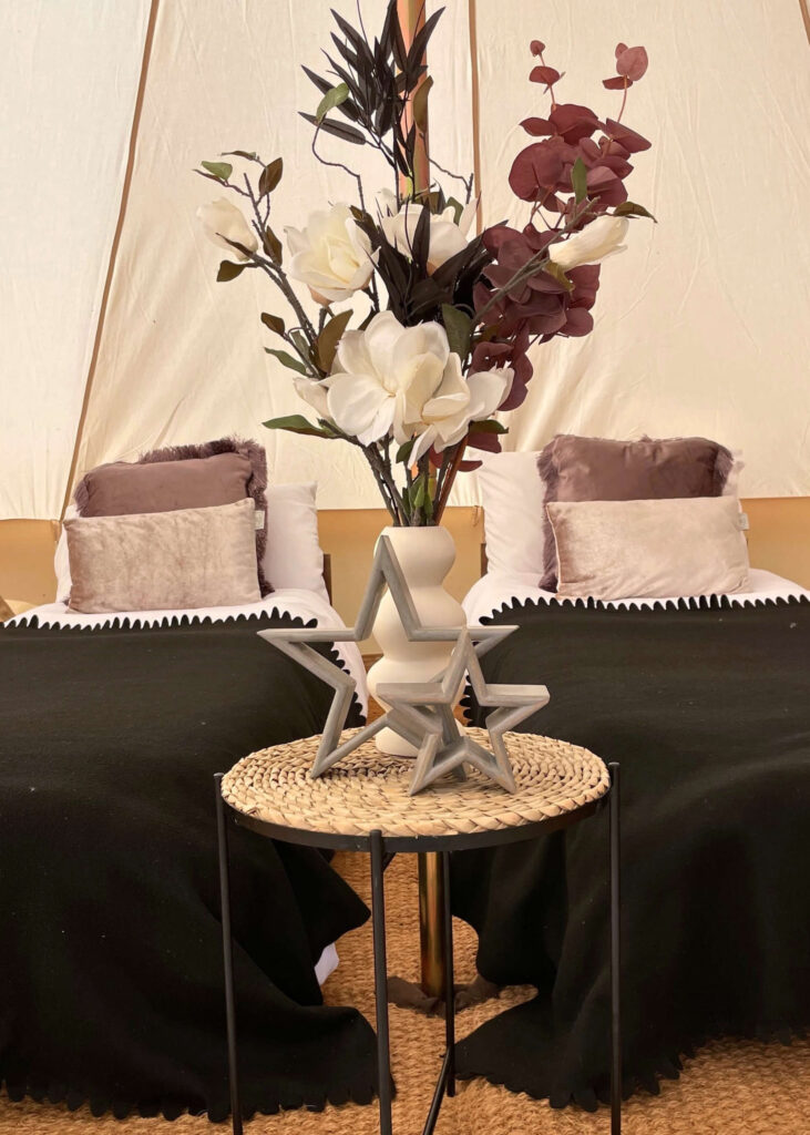 Wedding glamping tent interior dressed in black, mulberry, and champagne tones